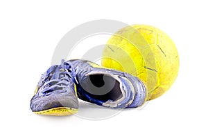 Old football shoes damaged and old dirty yellow futsal ball on white background football object isolated