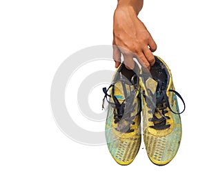 Old Football soccer player holding football boots cleats in hand on white background.