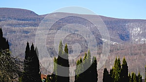 Old forested mountains against the blue sky. Mountainous landscape. Panorama.