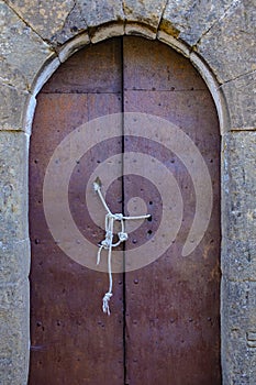 Old forged rusty metal door tied and secured with a rope