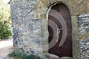 Old forged rusty metal door tied and secured with a rope