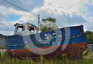 Old forgotten blue fisher boat abandoned in the harbour of New port Belgium