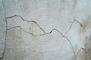 Old foundation and plaster wall with cracks. Building requiring repair closeup. photo