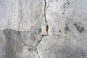 Old foundation and plaster wall with cracks. Building requiring repair closeup. photo