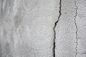 Old foundation and plaster wall with cracks. Building requiring repair closeup