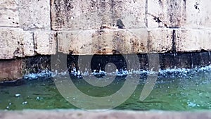 Old fountain in Matera with the water falling down and the drops bounce, historical monument and