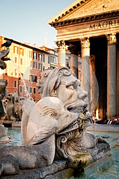 Old fountain next to the Pantheon in Rome at sunset