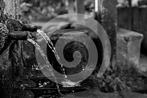 Old fountain poursing water from two spouts