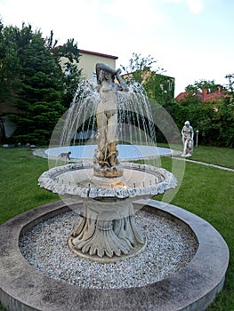 An old fountain with a woman sclupture in a romanian house yard.