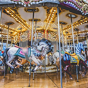 Old French carousel in a holiday park. Three horses and airplane