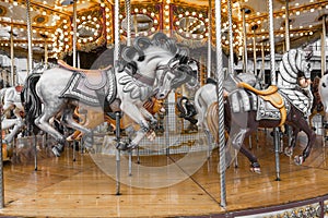 Old French carousel in a holiday park. Three horses and airplane