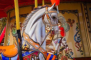 Old French carousel in a holiday park. Three horses and airplane on a traditional fairground vintage carousel. Merry-go-round with