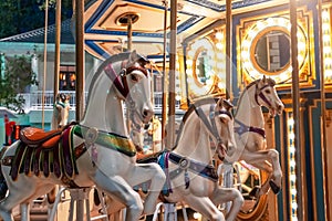 Old French carousel spins in a holiday park. Elephant horses on a traditional vintage fairground carousel, evening at