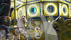 Old french carousel spins in a holiday park. Elephant horses on a traditional vintage fairground carousel, evening at