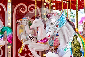 Old French carousel spins in a holiday park. Elephant horses on a traditional vintage fairground carousel, evening at