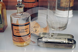 Old French medical bottle with Tincture of strophanthus next to old syringe