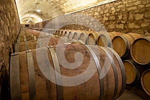 Old french oak wooden barrels in cellars for wine aging process, wine making in La Rioja region, Spain