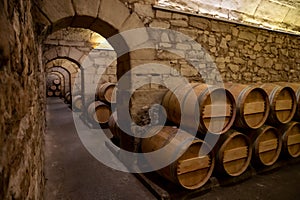 Old french oak wooden barrels in cellars for wine aging process, wine making in La Rioja region, Spain