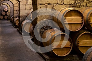 Old french oak wooden barrels in cellars for wine aging process, wine making in La Rioja region, Spain