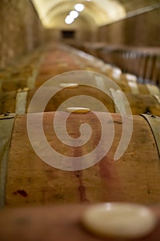 Old french oak wooden barrels in cellars for wine aging process, wine making in La Rioja region, Spain