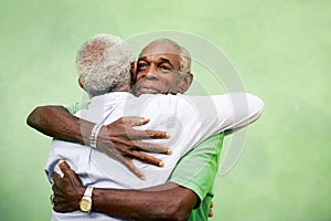 Old friends, two senior african american men meeting and hugging