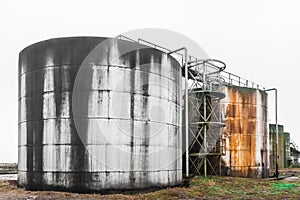 Old fuel oil tanks with fuel oil stains and traces of rust at an abandoned industrial plant