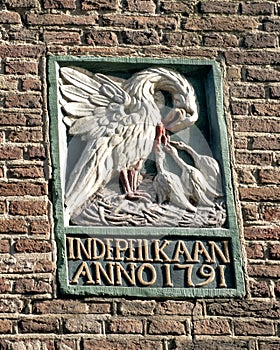 Old gable stone with mother pelican injuring her own chest to feed her starving young with her own blood, Amsterdam