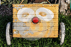 An old garden cart with a funny face painted on it