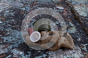 The old gas mask lies on a destroyed concrete floor, a symbol of