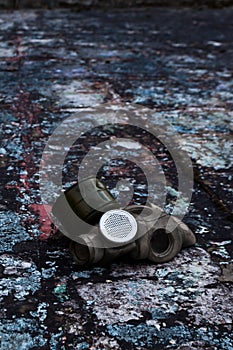 The old gas mask lies on a destroyed concrete floor, a symbol of