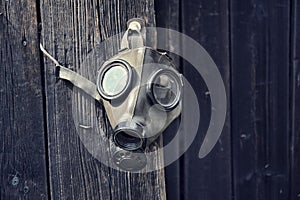 Old gas mask on wooden background, terrorism pollution apocalypse concept