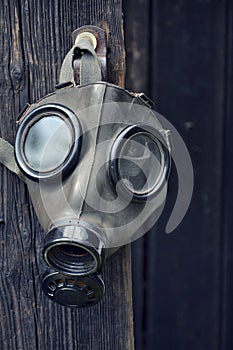 Old gas mask on wooden background, terrorism pollution apocalypse concept