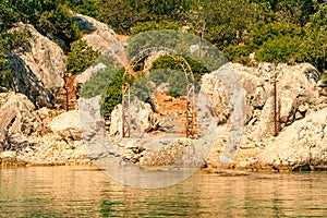 The old gate arch and the path leading from the bay of the Mediterranean Sea to the ruins of the old Lycian fortress on the hill