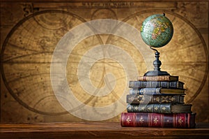 Old geographical globe and old book on map background. Science, education, travel background. History and geography team. Ancience