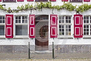 Old German house with wooden door and windows with wooden shutters, Wachtendonk