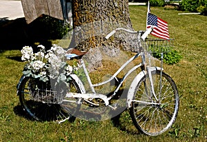 Old girl`s bike decorated with flowers and a flag.