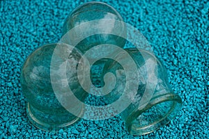 Three old glass medical jars on blue sand