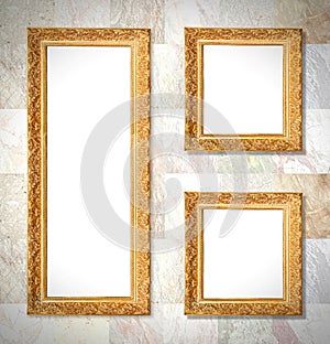 An old gold frames hanging on a marble wall