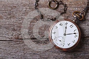 Old gold pocket watch on a chain on an old woodenï¿½