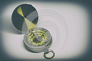 An old golden compass on a white background