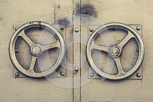 Old golden door handle. The metallic corn-coloured door knob in the shape of aureate steering wheel. Two metallic gold door handle