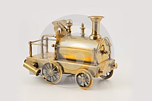 Old golden toy steam locomotive on isolated background