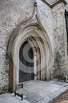 Old gothic arched door with wooden door and metal grill entrance into an old church