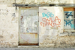 Old graffiti wall with metal door and window.