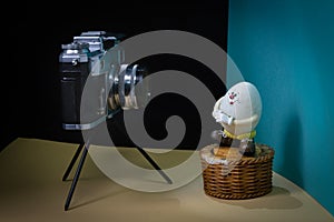 Old grandfather`s camera and Humpty-Dumpty`s toy on a blue background.