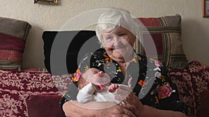 An old grandmother is rocking a little baby in her arms