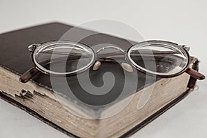 Old grandmother`s glasses and a dilapidated book