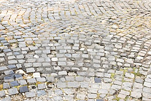 Old granite cobblestone pavement or road pattern texture. Regular rows of granite paving stones background
