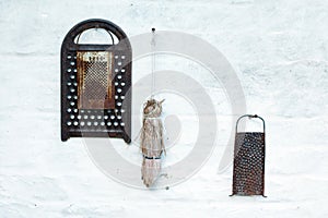 Old grater hanging on a brick wall