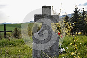 Old grave on traditional European cemetery in Slovakia. Aged cross tomb stone on grave yard in spring